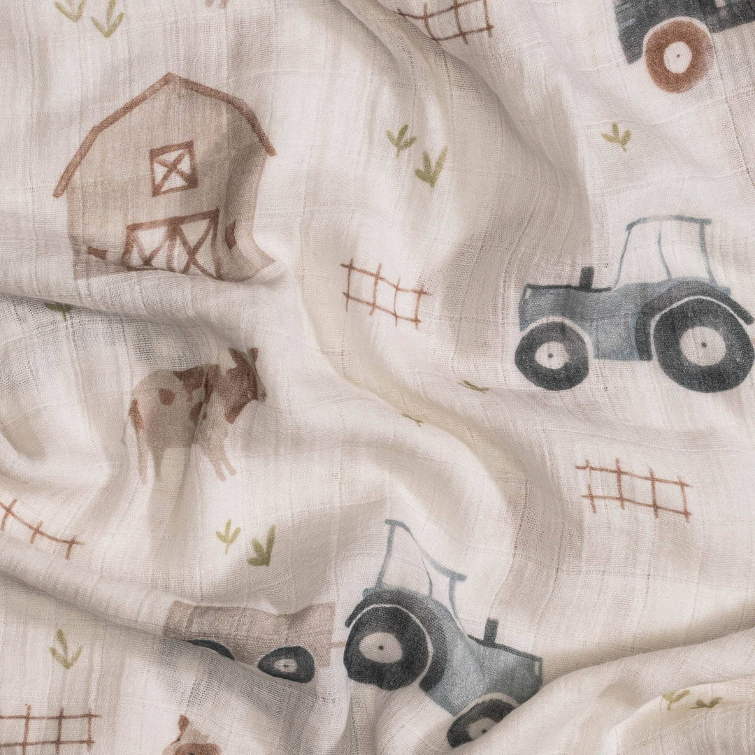 close view of farmhouse tractor crane baby swaddle print perfect for newborn boy  