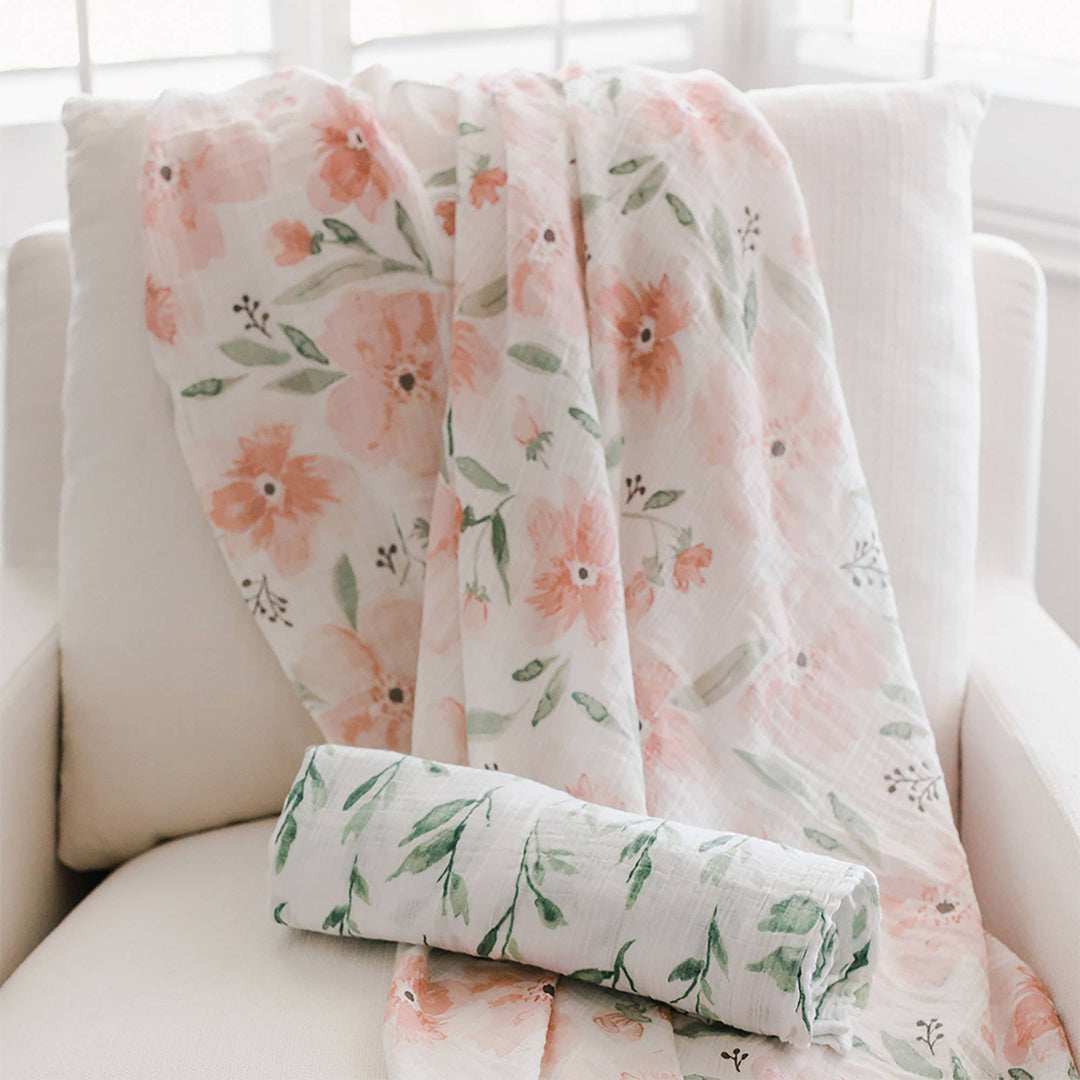 pink floral cotton muslin baby swaddles crane baby in neutral minimalist nursery 