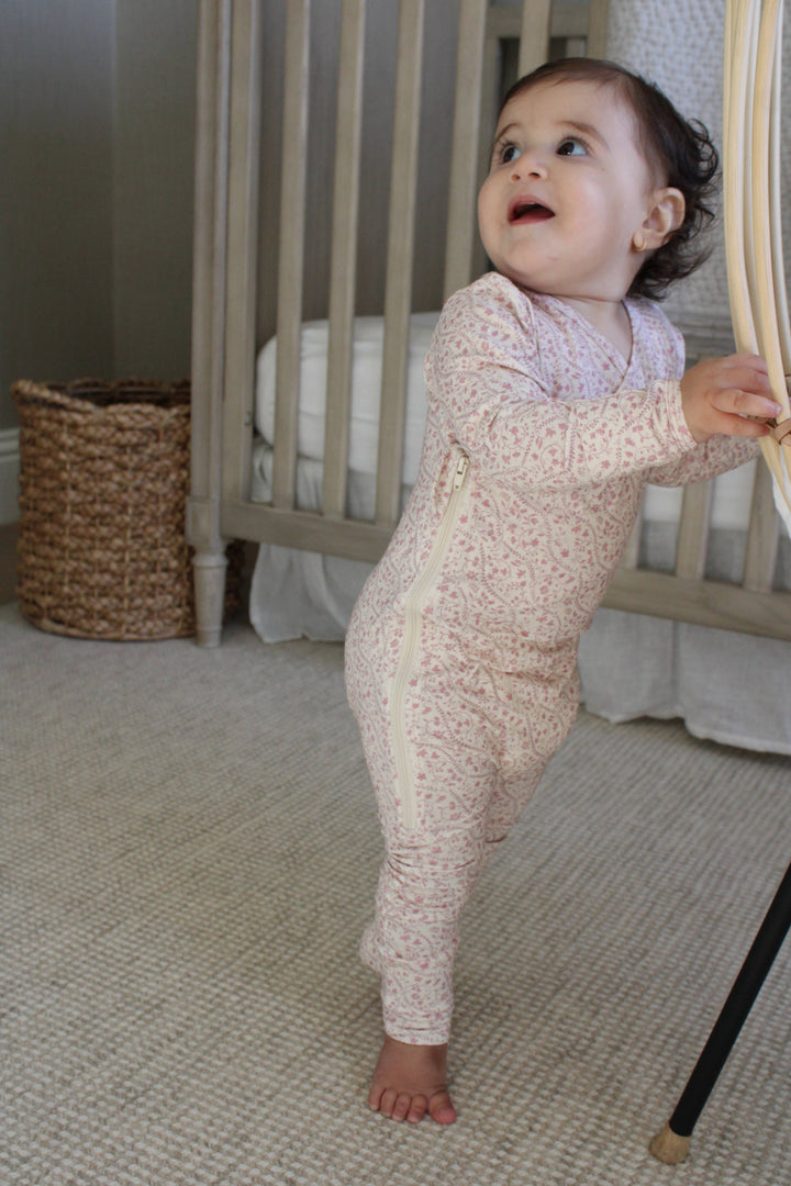 Heirloom vine print footie from Little Threads on baby standing at a crib rail