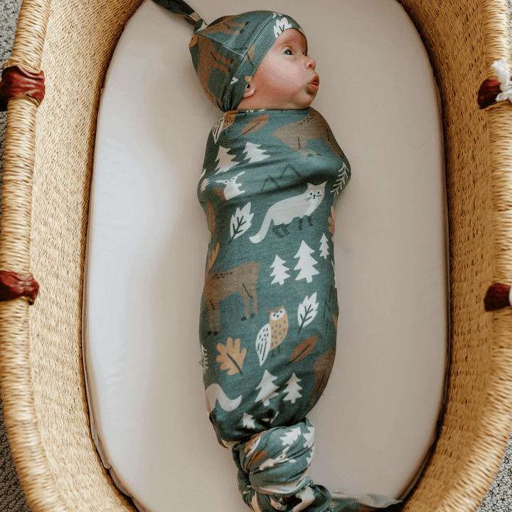 Newborn swaddled in Copper Pearl Atwood knit receiving blanket
