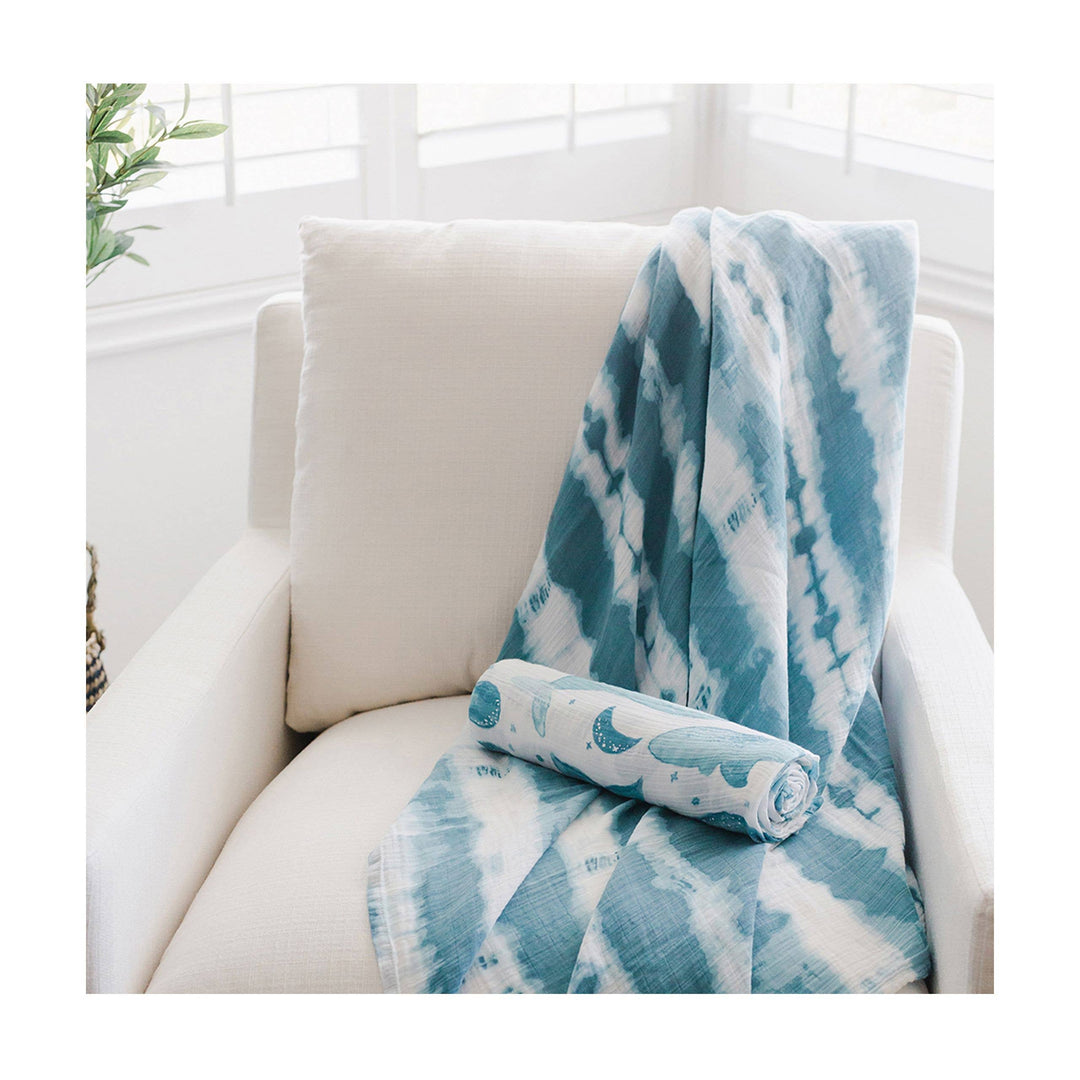 nursery with soft blue whale patterned cotton nwborn swaddle set by crane baby organic 