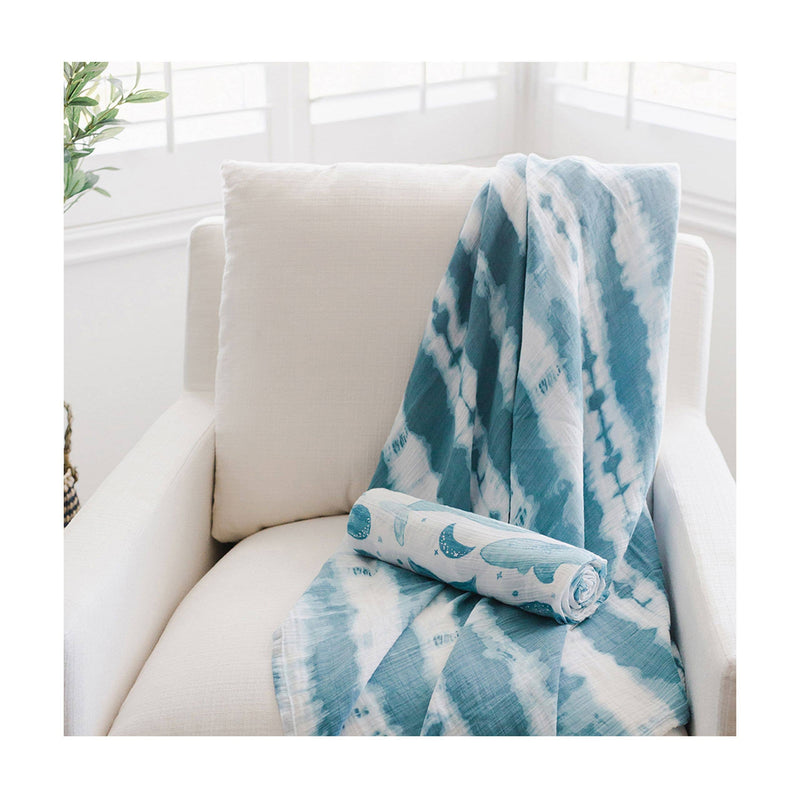 nursery with soft blue whale patterned cotton nwborn swaddle set by crane baby organic 