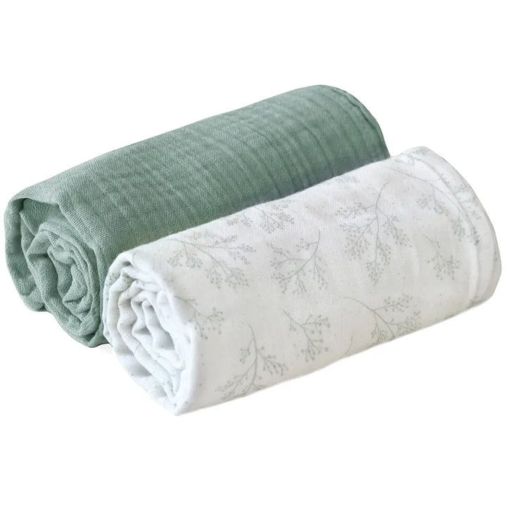 Flat lay presentation shows the Charlie Crane DOLI Swaddle Set in milk camel and lichen with a soft feel for gentle use