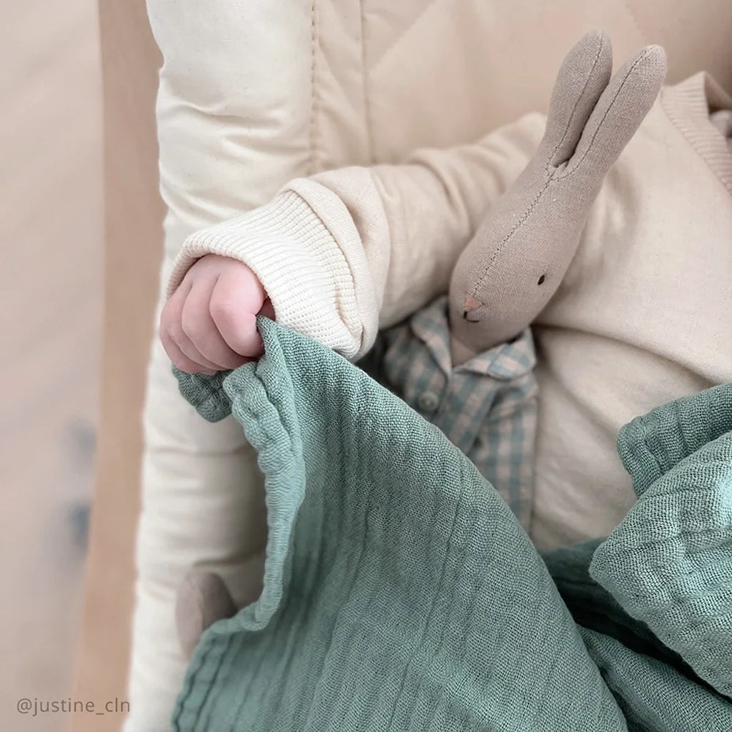 Modern baby essential shows the Charlie Crane DOLI Swaddle Set in milk camel and lichen crafted for infant use