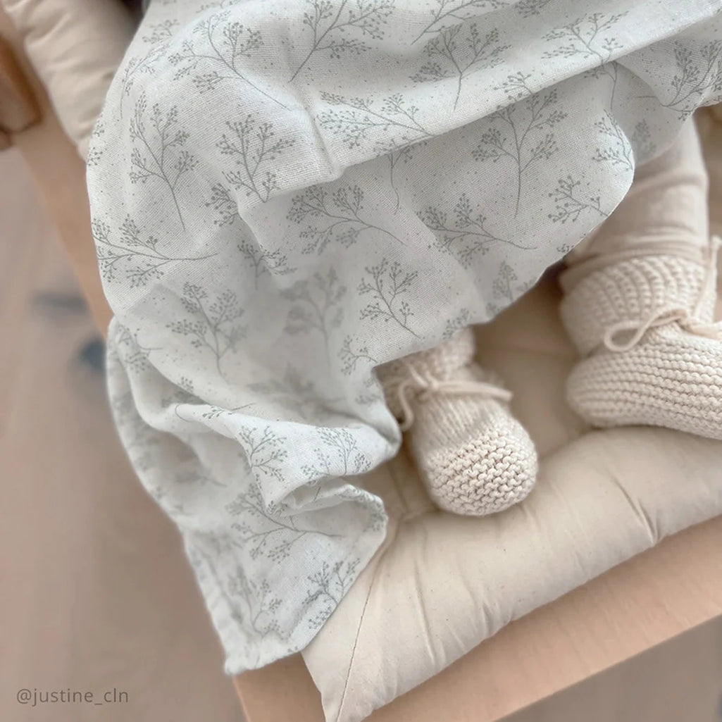 Neutral toned bundle displays the Charlie Crane DOLI Swaddle Set in milk camel and lichen as a breathable swaddling blanket