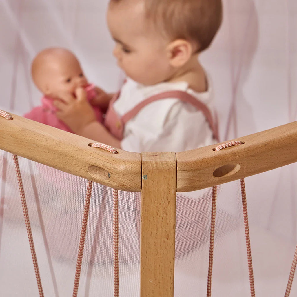 Playful nursery scene shows the Charlie Crane KIMI Baby Evolving Bed in bois de rose with a handcrafted, safe design