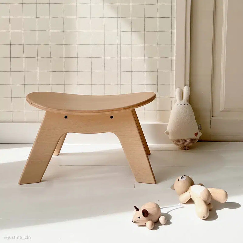 Playful nursery scene shows the Wooden HIBO Stool by Charlie Crane in natural created for baby safe use