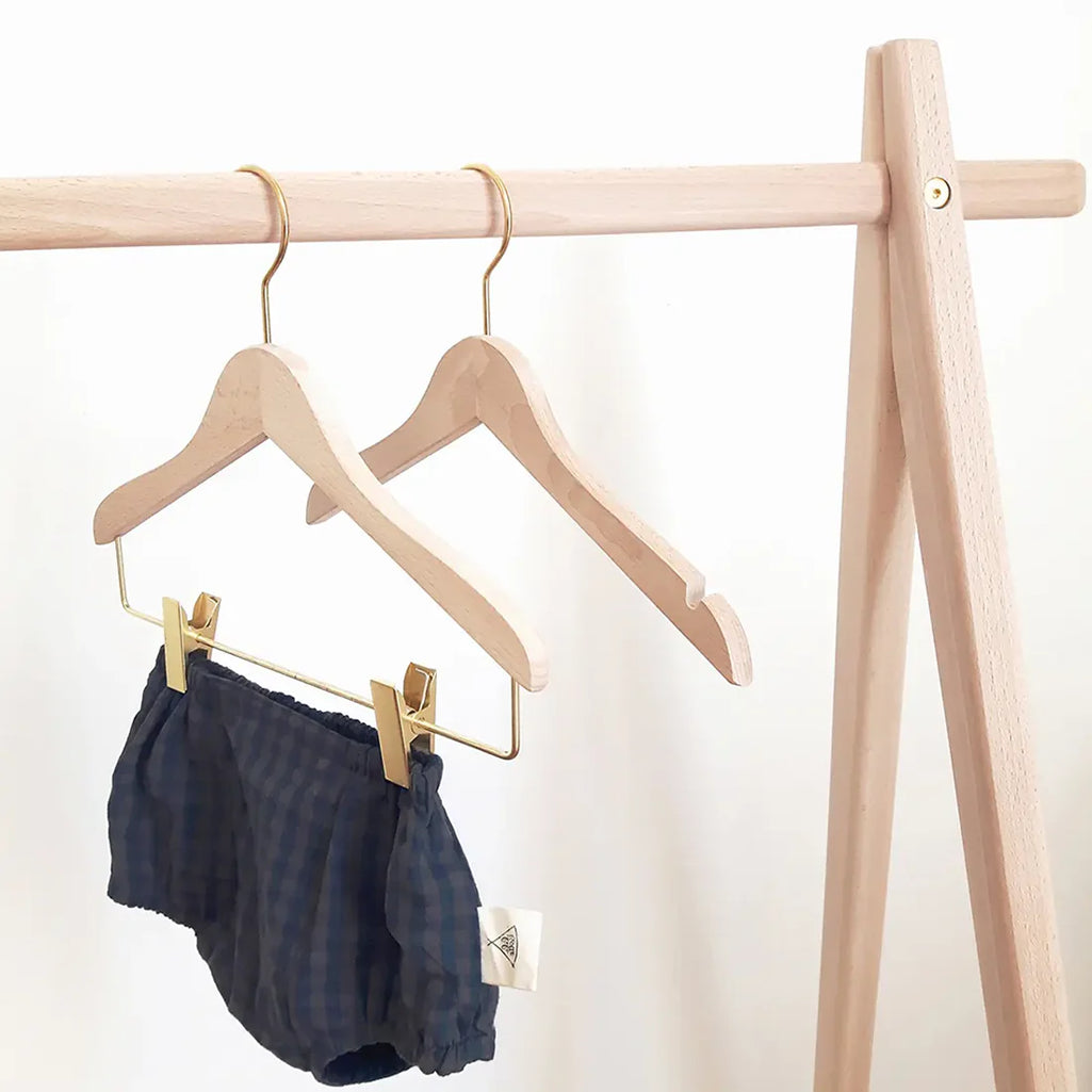 Angled nursery view shows the Charlie Crane HOMI Hangers in natural designed for baby clothing