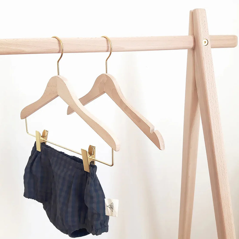 Angled nursery view shows the Charlie Crane HOMI Hangers in natural designed for baby clothing