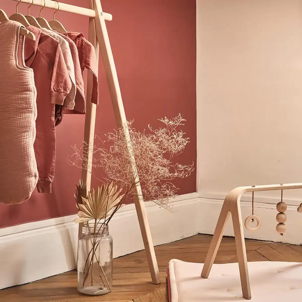 Soft lit nursery scene displays the Charlie Crane HOMI Rack in natural with a sophisticated and airy look