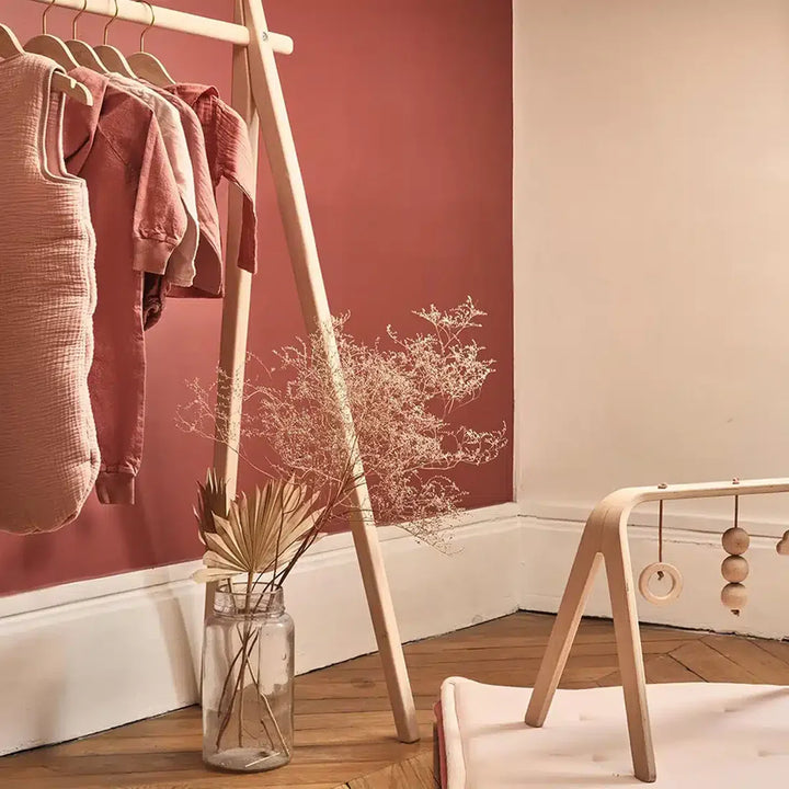 Soft lit nursery scene displays the Charlie Crane HOMI Rack in natural with a sophisticated and airy look