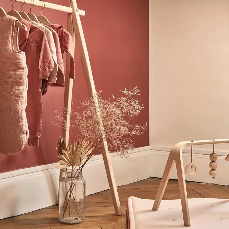 Soft lit nursery scene displays the Charlie Crane HOMI Rack in natural with a sophisticated and airy look