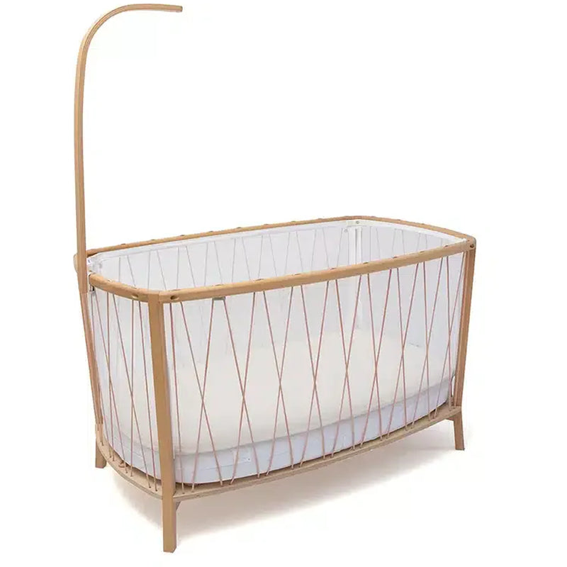 Soft light emphasizes the Charlie Crane Wooden KANO Bed Arrow in natural for a sophisticated crib canopy
