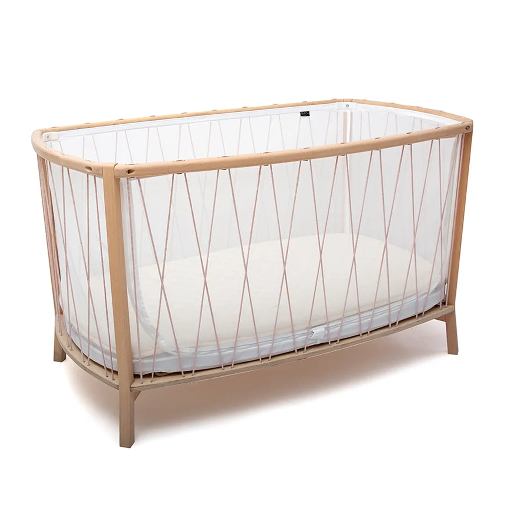 Warm lighting accentuates the KIMI Evolving Bed by Charlie Crane in desert as a handcrafted child bed with European beech frame