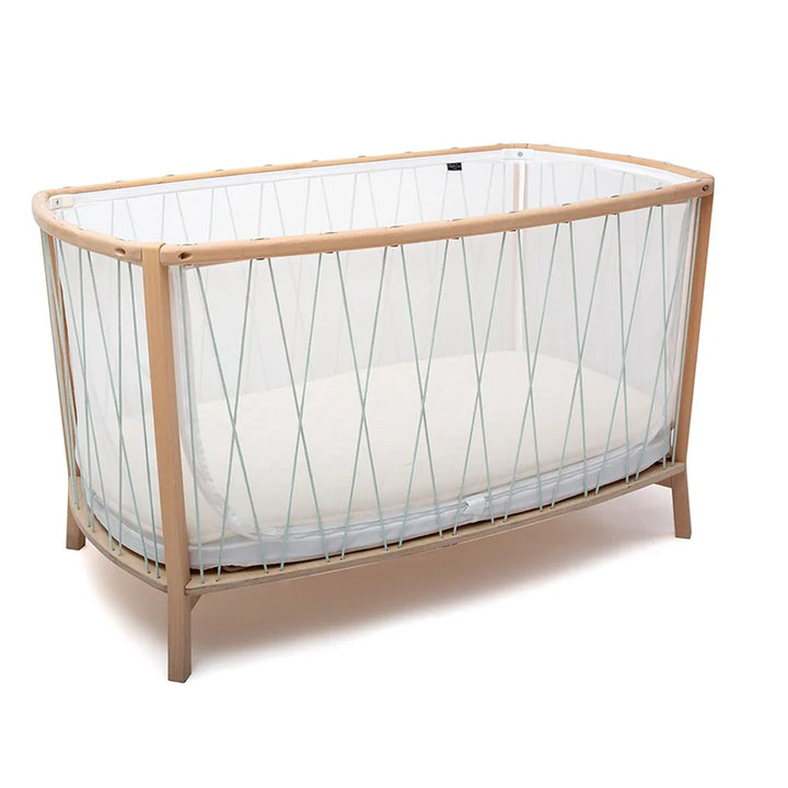Handcrafted furniture detail highlights the KIMI Evolving Baby Bed Charlie Crane in hazelnut with a coconut fiber mattress for infant safety