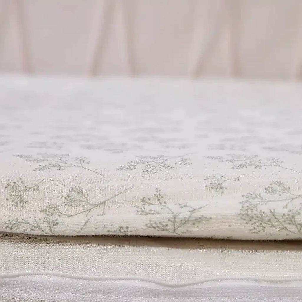 Pearl blossom nursery accent shows the KIMI Evolving Baby Bed Charlie Crane with natural organic crib sheet