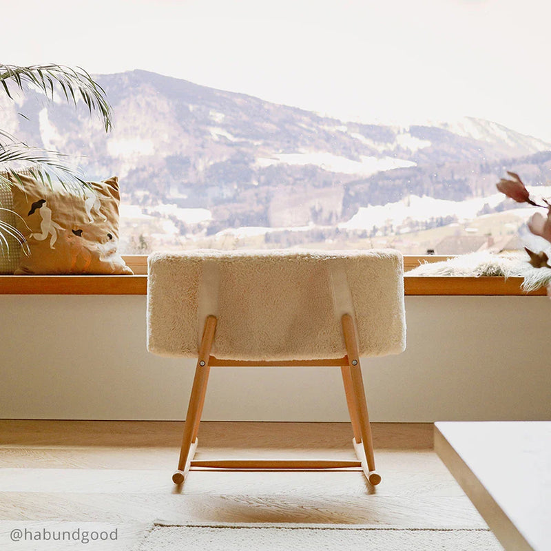 Timeless nursery styling features the Charlie Crane KUKO Bassinet in milk fur as a gentle rocking bassinet