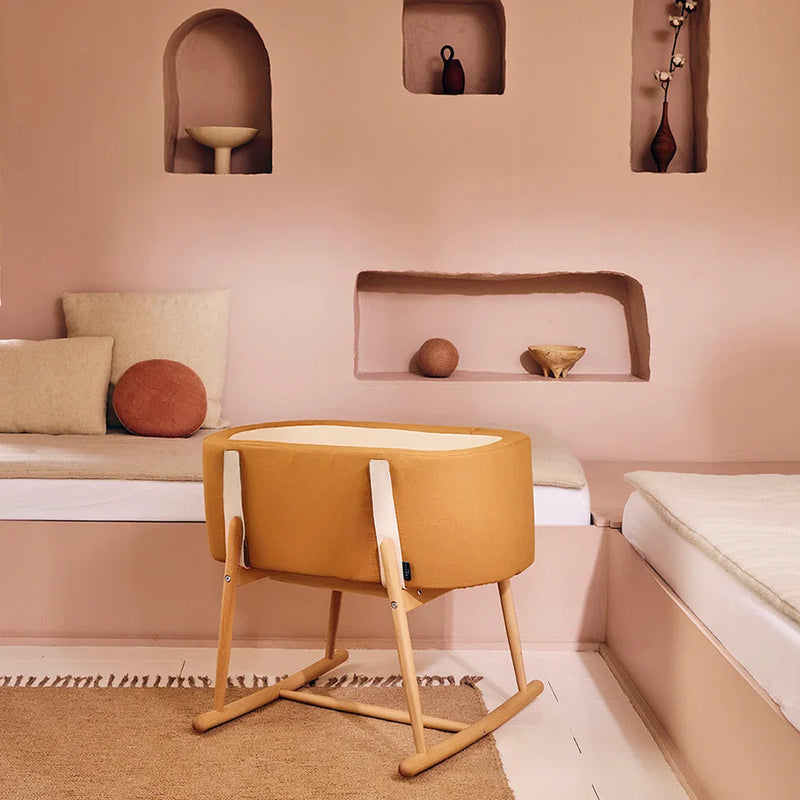 Soothing newborn scene shows the Bassinet KUKO Charlie Crane in camel that is newborn safe