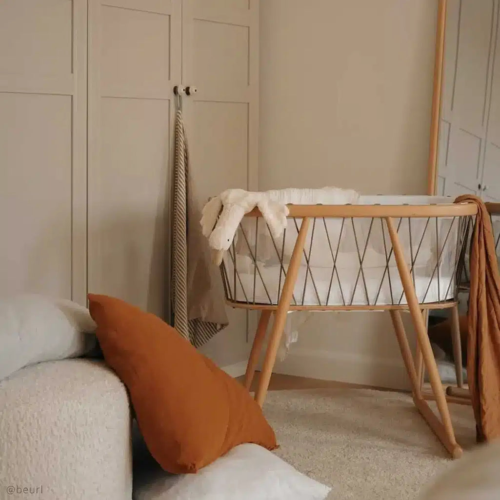 Detail focused image captures the Charlie Crane KUMI Cradle bois de rose crafted from rounded wood