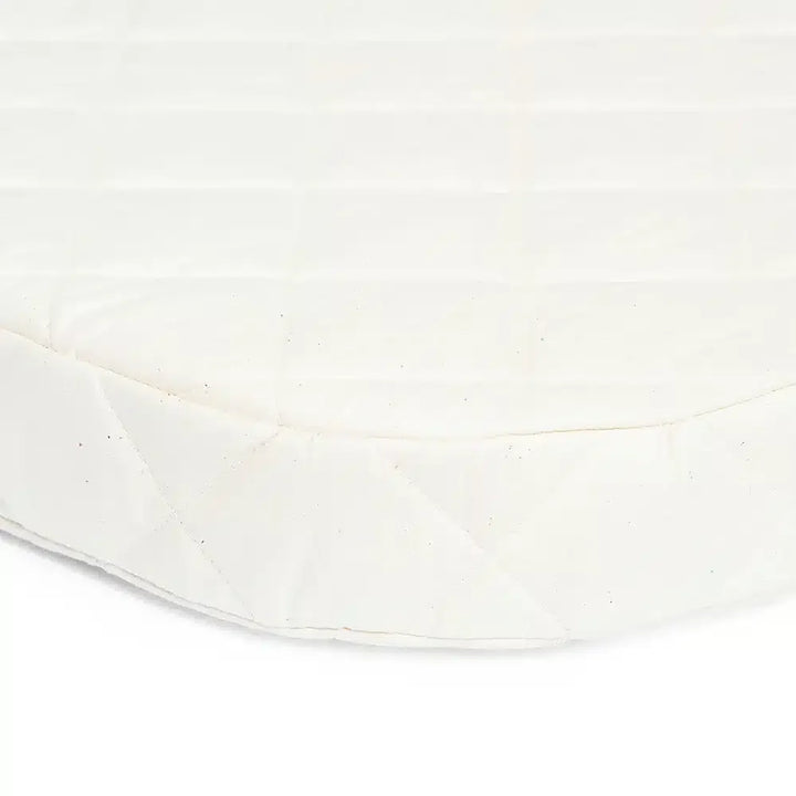 Peaceful infant setup shows the KUMI Charlie Crane Cradle in lichen with infant safe construction