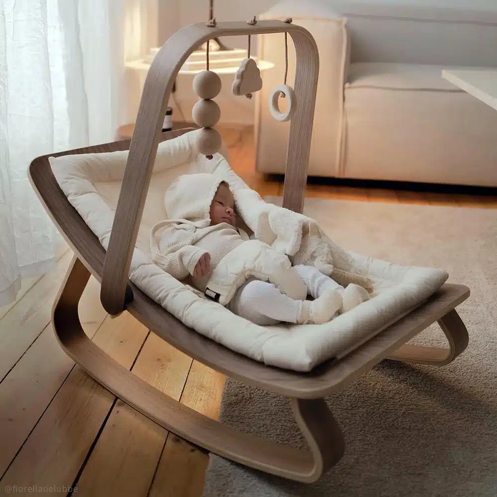 sustainable european walnut infant rocker with organic cushion and non toxic baby mobile created by charlie crane 