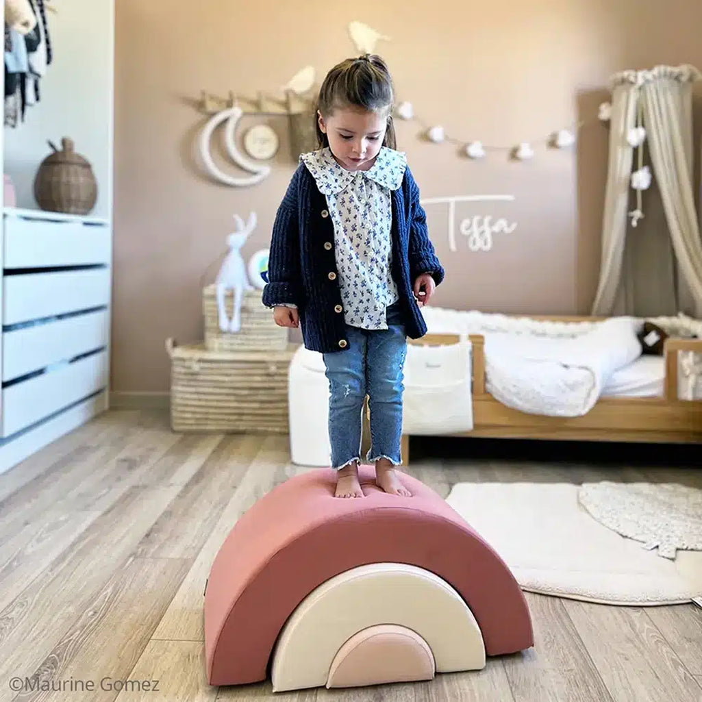 Thoughtful play setup presents the Charlie Crane MILO Rainbow Toy in rosewood designed for infants