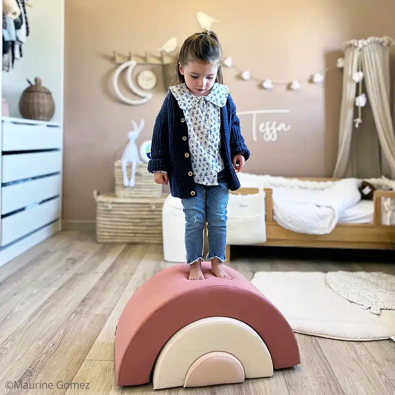 Thoughtful play setup presents the Charlie Crane MILO Rainbow Toy in rosewood designed for infants