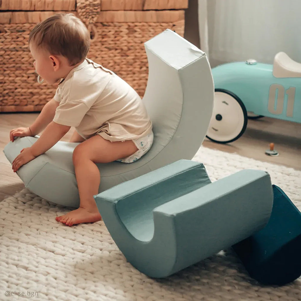 Warm light emphasizes the MILO Rainbow Play Toy by Charlie Crane in rosewood as minimalist nursery decor
