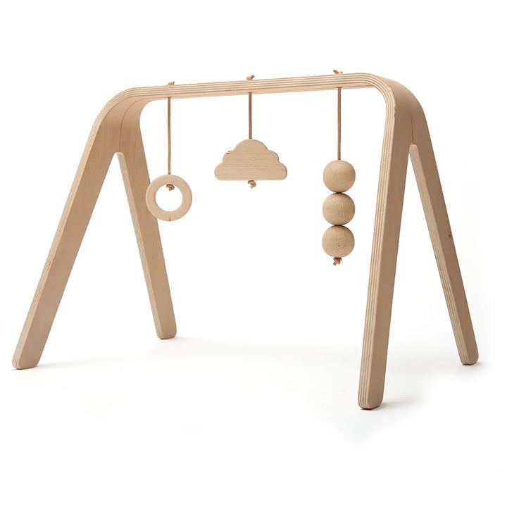 Angled nursery scene shows the Charlie Crane NAHO Arch & Toys in natural with a midcentury modern play gym design