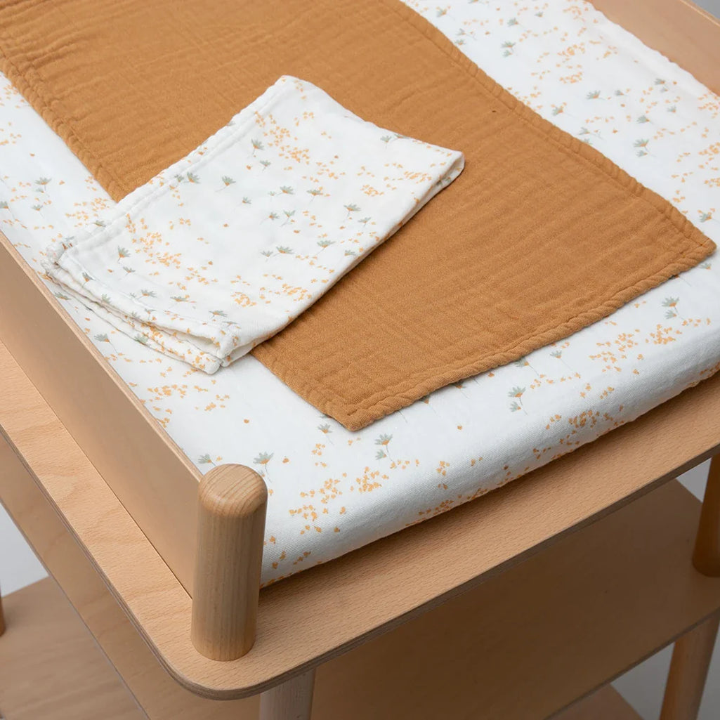 yellow pia flowers with camel brown swaddle on charlie crane nago diaper changing mat