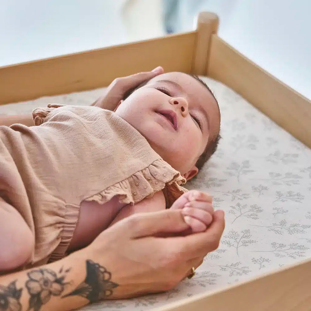 baby laying on pago charlie crane changing table matttress 