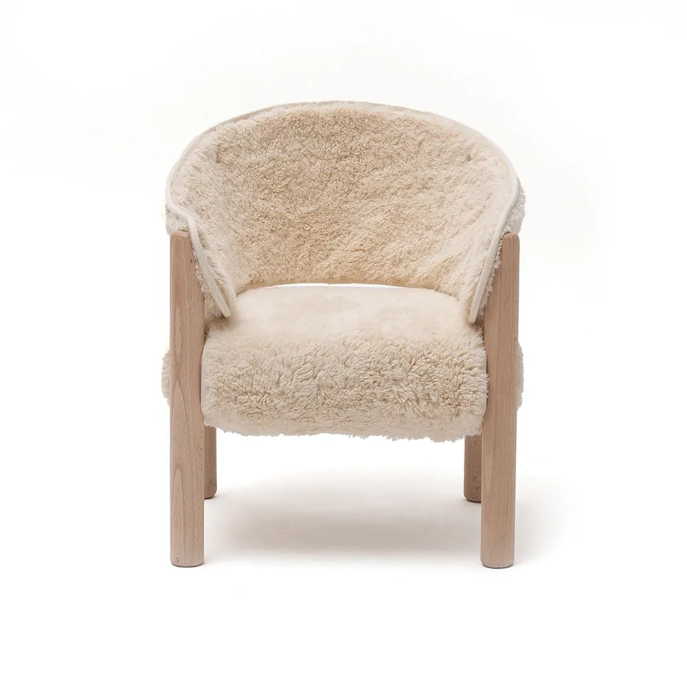 Soft textured seating highlights the Charlie Crane SABO Fur Chair in milk crafted with wooden legs