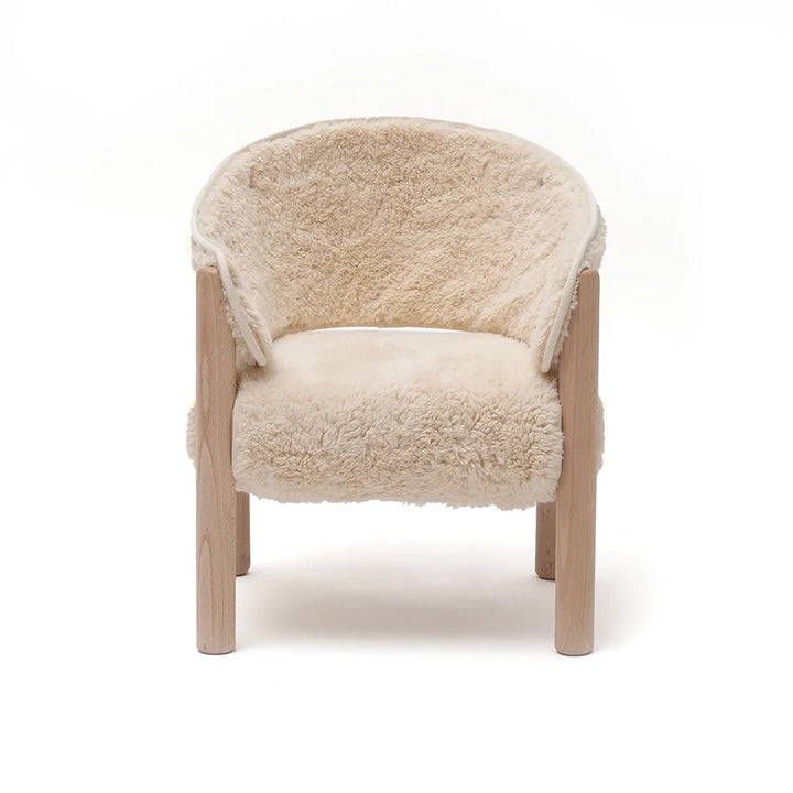 Soft textured seating highlights the Charlie Crane SABO Fur Chair in milk crafted with wooden legs