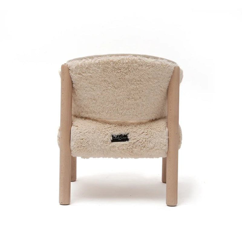 Cozy reading corner shows the Charlie Crane SABO Fur Chair in milk with a sophisticated nursery decor look