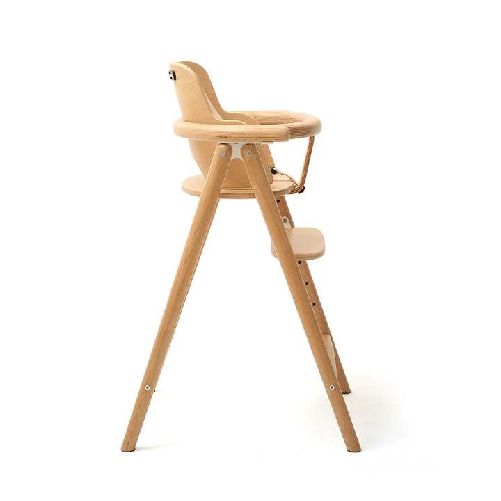 Side profile of Charlie Crane TOBO Baby Set Kit in Natural, a slim, space-saving wooden high chair