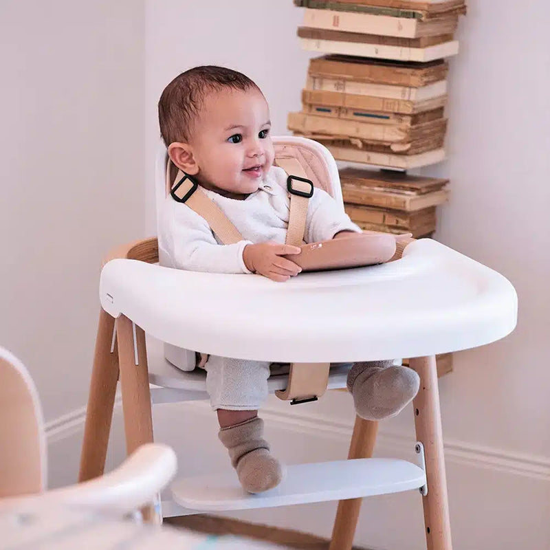 toddler sitting in charlie crane tobo high chair with white detachable tray for easy baby mealtime