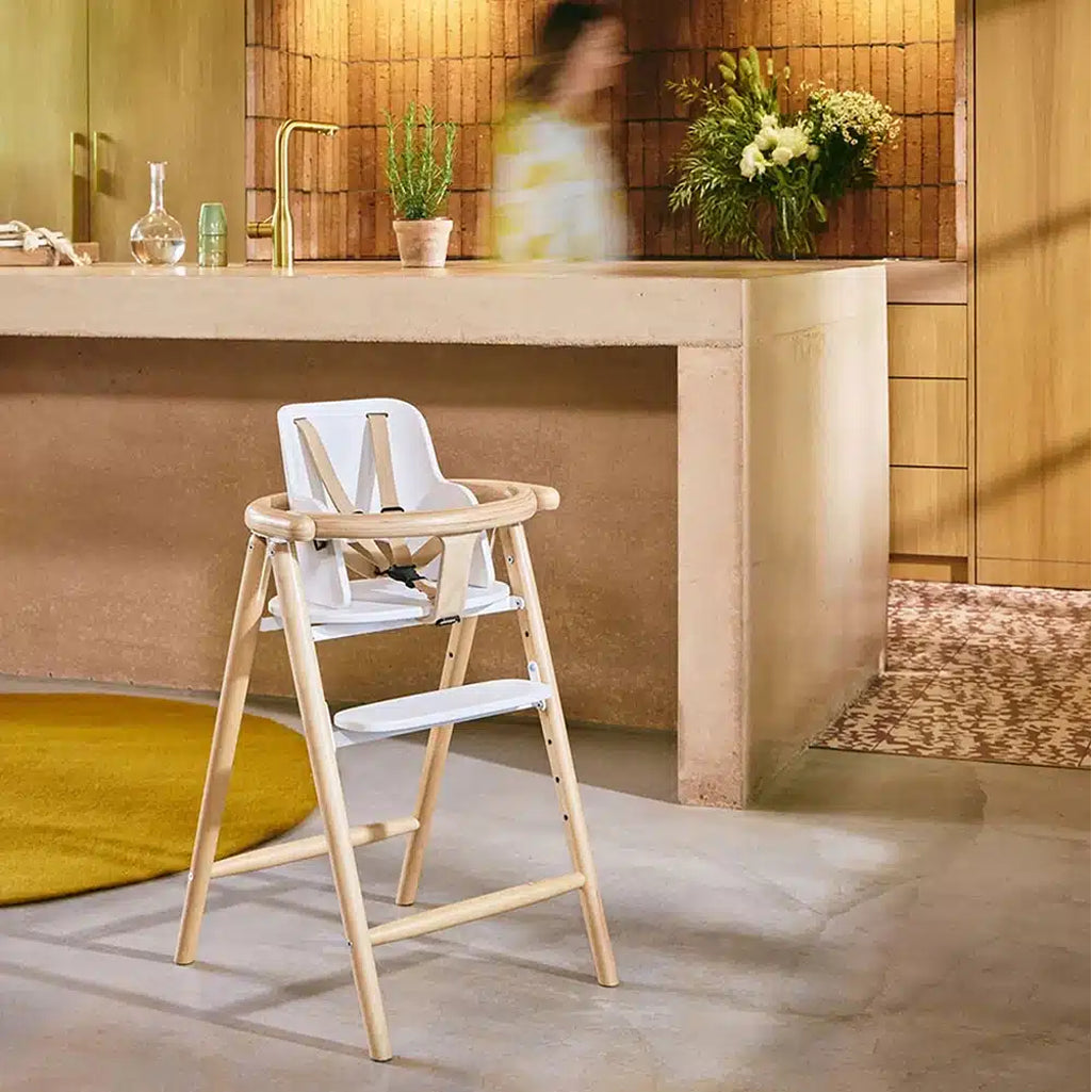 blurred person walking in boho kitchen with sophisticated modern charlie crane high chair 