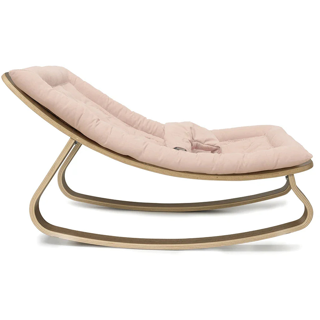 A cozy setup featuring the Charlie Crane Walnut Wood Levo Rocker in organic milk, created for infant safe lounging