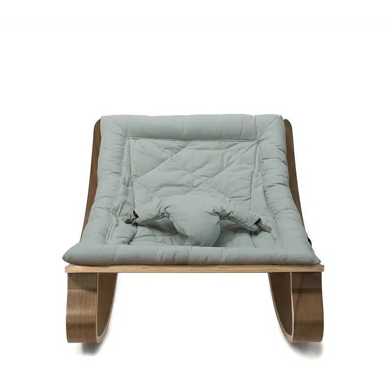 A serene nursery scene with Charlie Crane Levo Rocker Walnut Wood in organic milk, styled with midcentury modern appeal