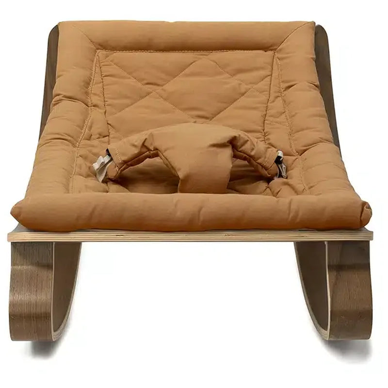 Textural focus on the walnut frame of the Levo Rocker by Charlie Crane in camel, an eco friendly infant rocker