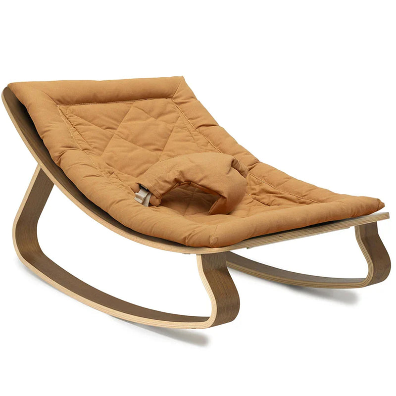 A soothing setup with the Charlie Crane Walnut Wood Levo Rocker in organic milk, designed for infant safe lounging
