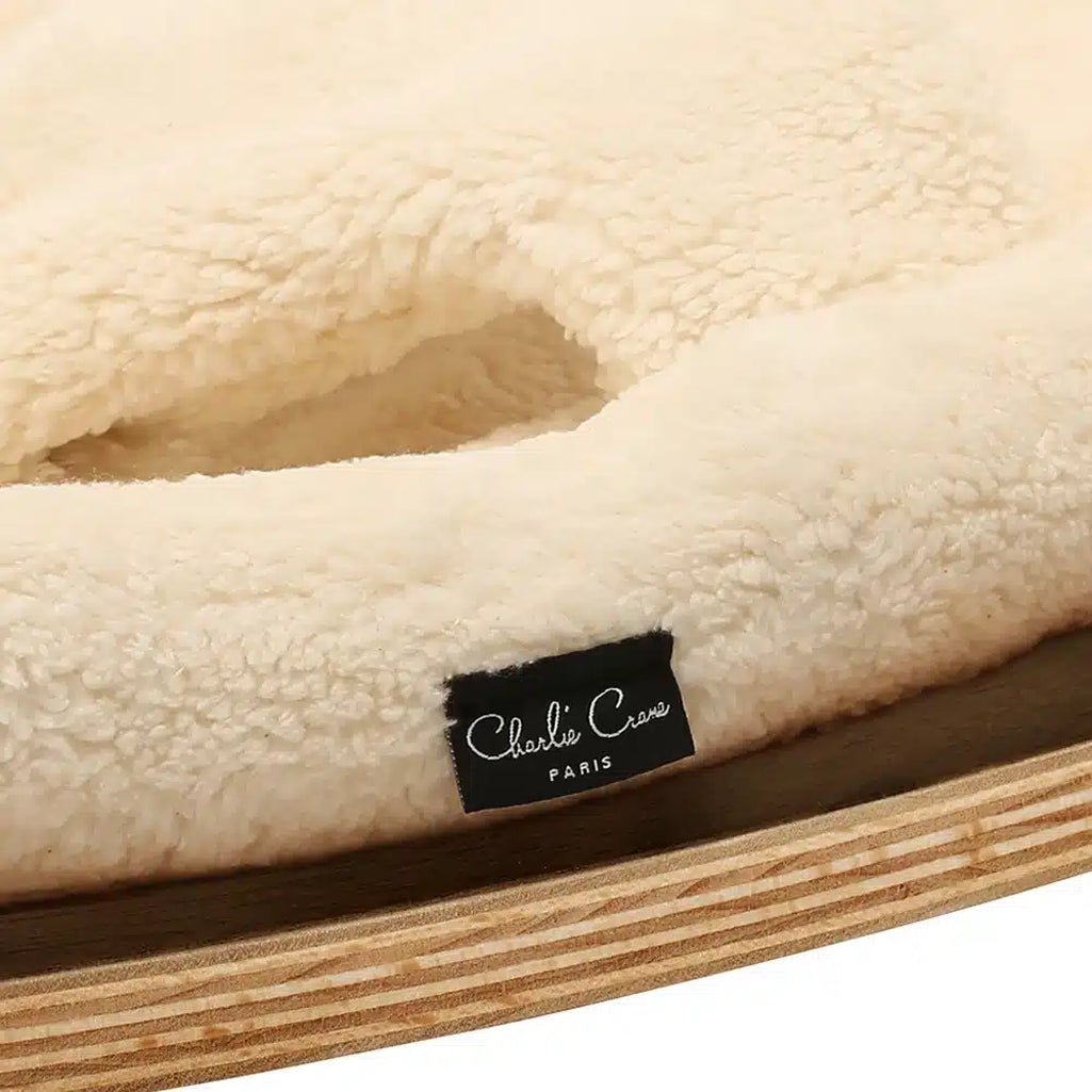 Elegant rounded shape defines the Charlie Crane Walnut Wood Levo Rocker in milk fur, crafted for infant comfort