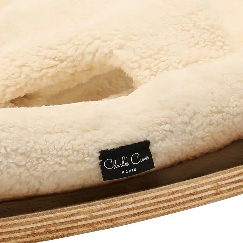 Elegant rounded shape defines the Charlie Crane Walnut Wood Levo Rocker in milk fur, crafted for infant comfort
