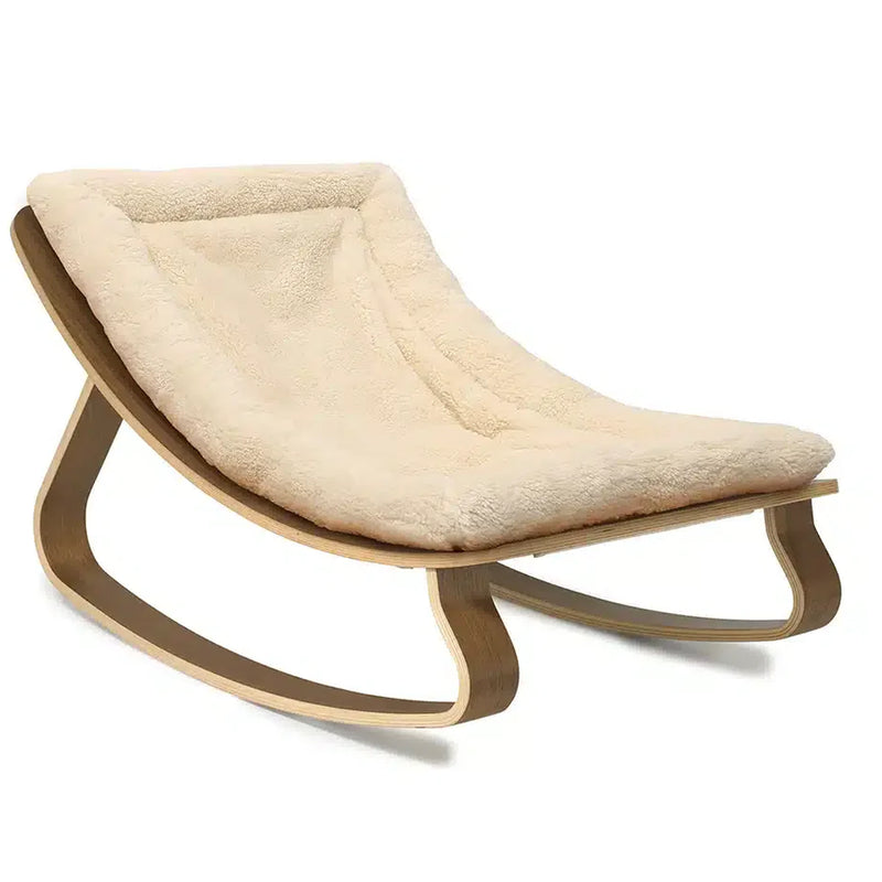 A calm nursery moment featuring Charlie Crane Levo Rocker Walnut Wood in organic milk with midcentury modern style