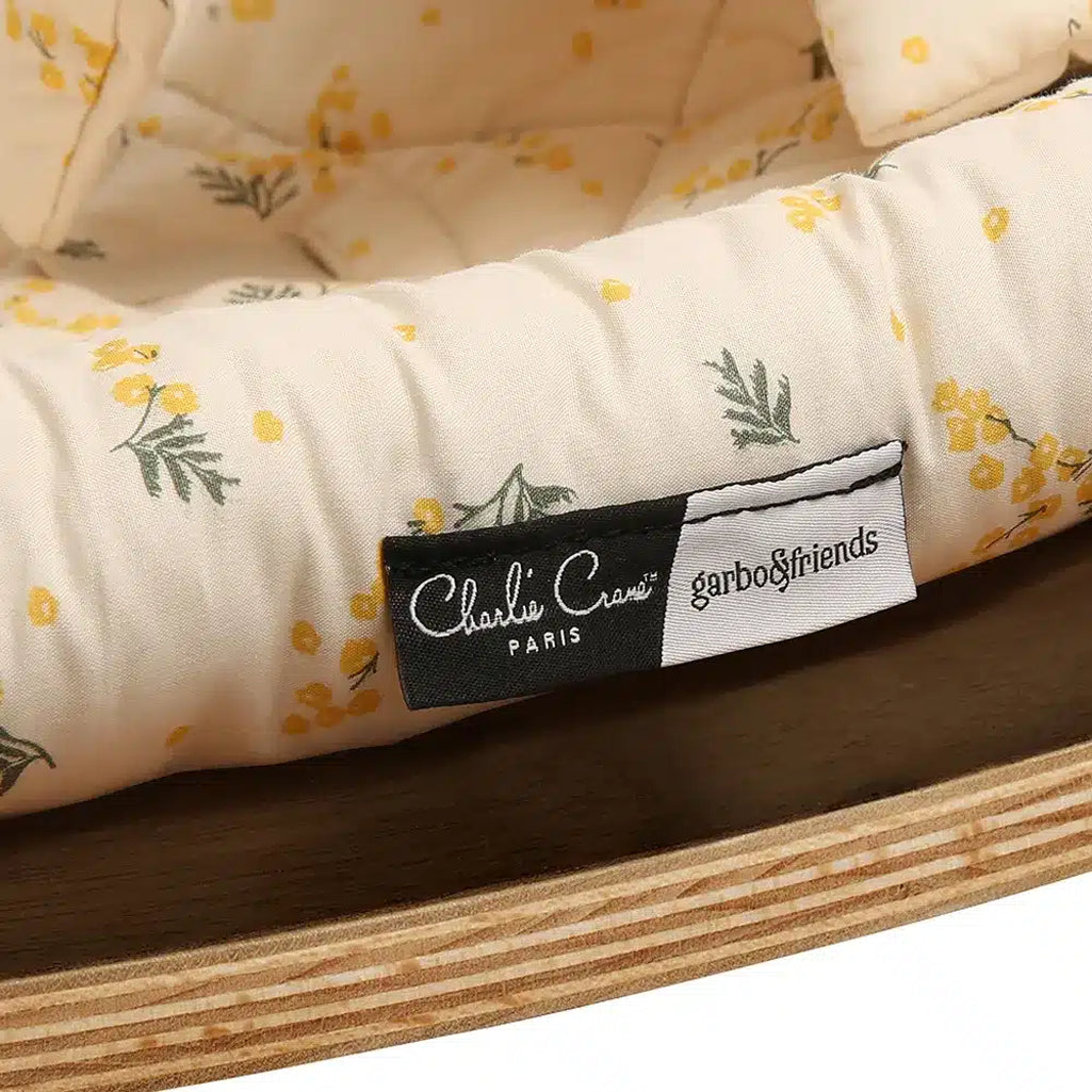 Close up detail of walnut wood craftsmanship on the Charlie Crane Levo Rocker in milk fur, showcasing sustainable materials