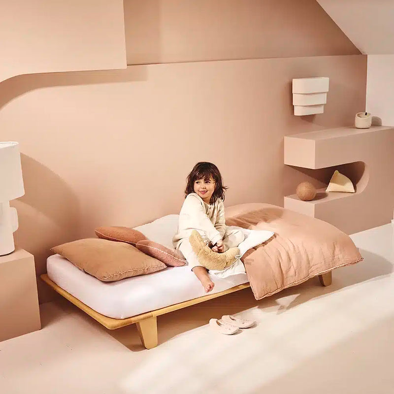 child sitting on charlie crane ypmi mattress and mod wooden kids bedframe 