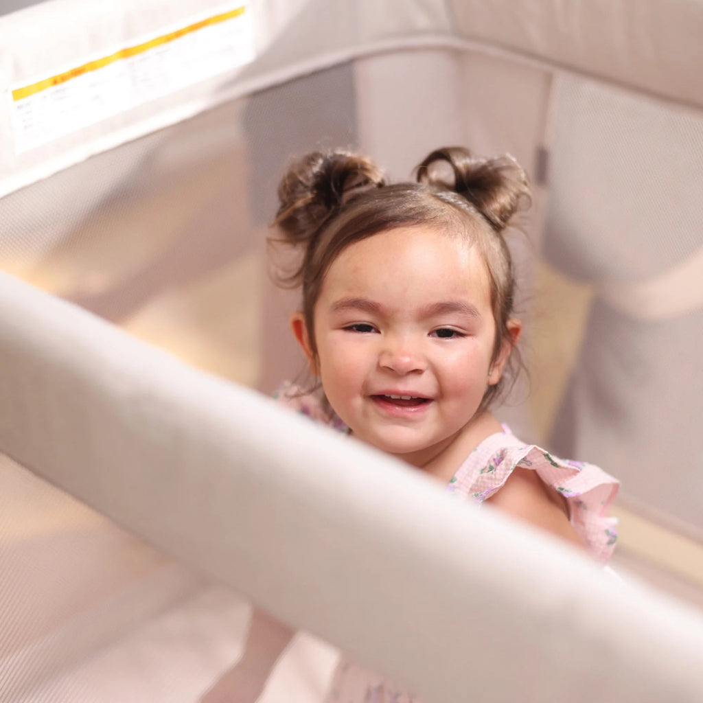 child smiling in Maxi Cosi Swift playpen for babies