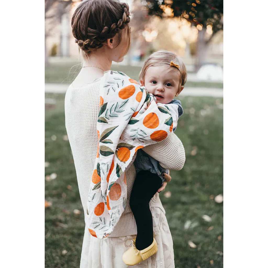 mother holding toddler with organic cotton swaddle