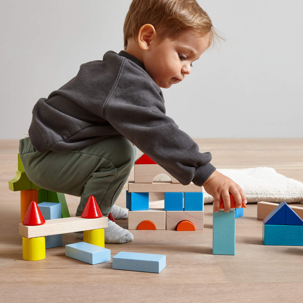 HABA Colored Wooden Building Blocks inspire creativity and problem-solving as a Montessori toy for kids.
