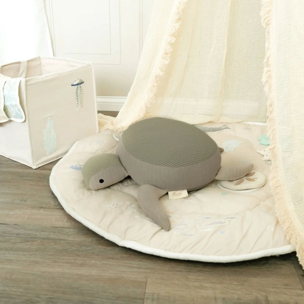 knit cotton crane baby stuffed animal toy laying on crane baby play mat 